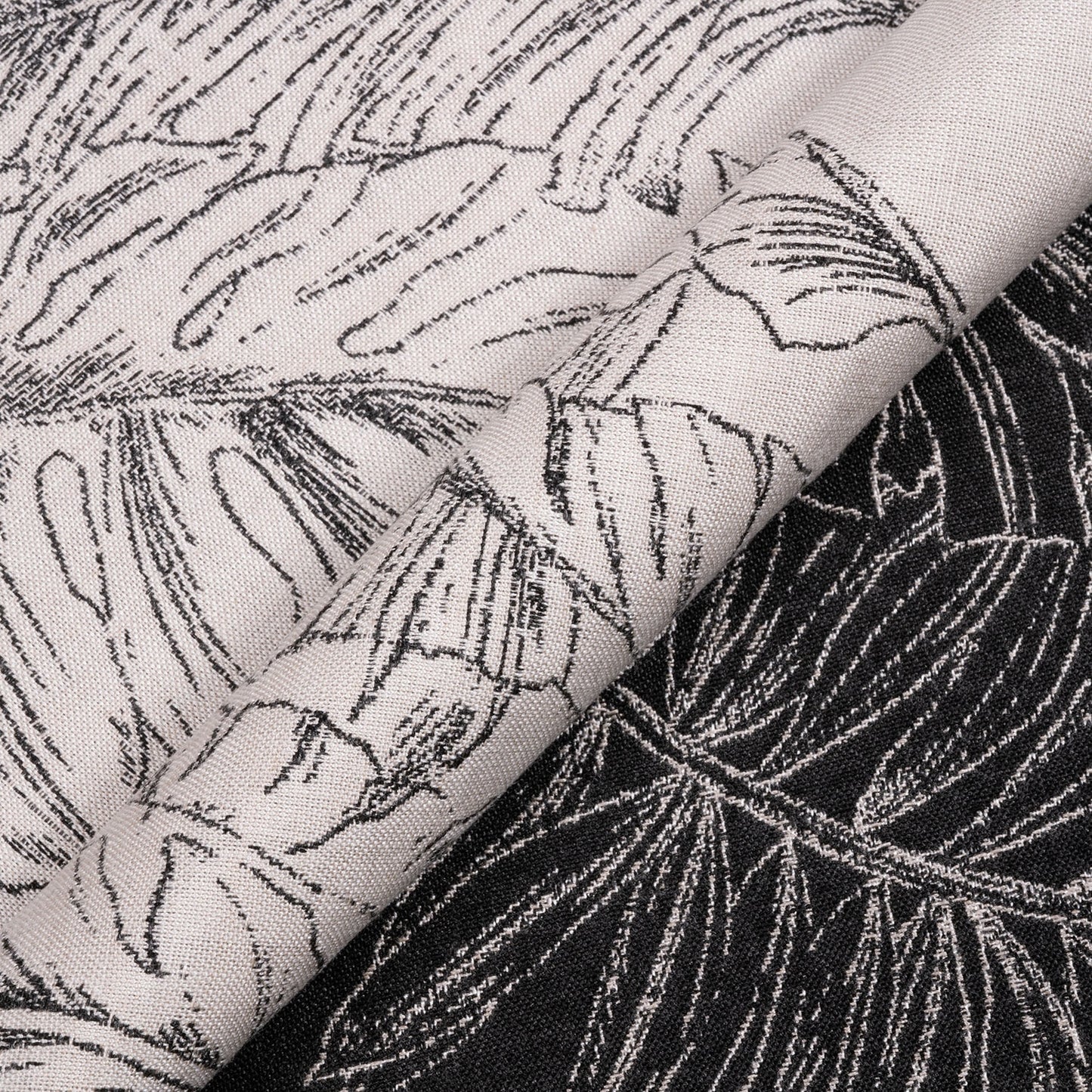 Close-up of fabric with black leaf pattern on a white background