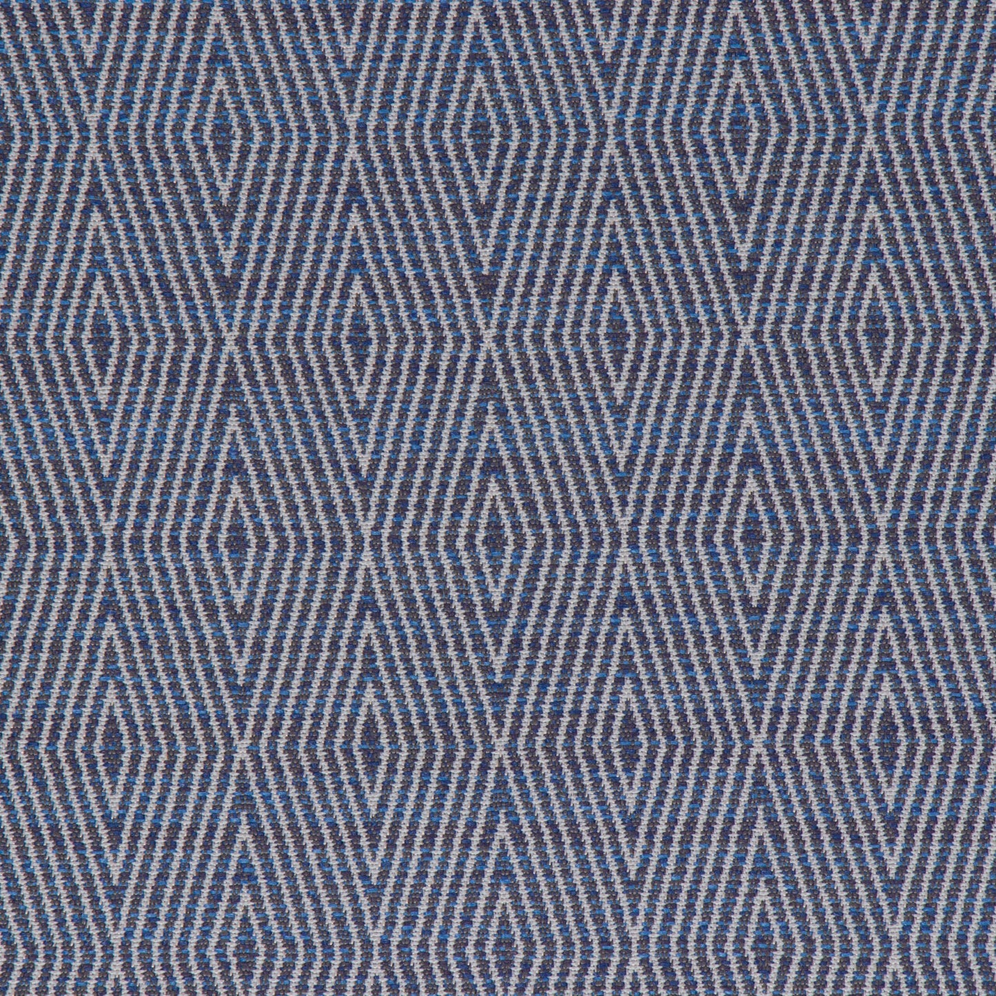 A close-up view of a fabric with a geometric pattern featuring diamond shapes in a variety of shades primarily in blue.