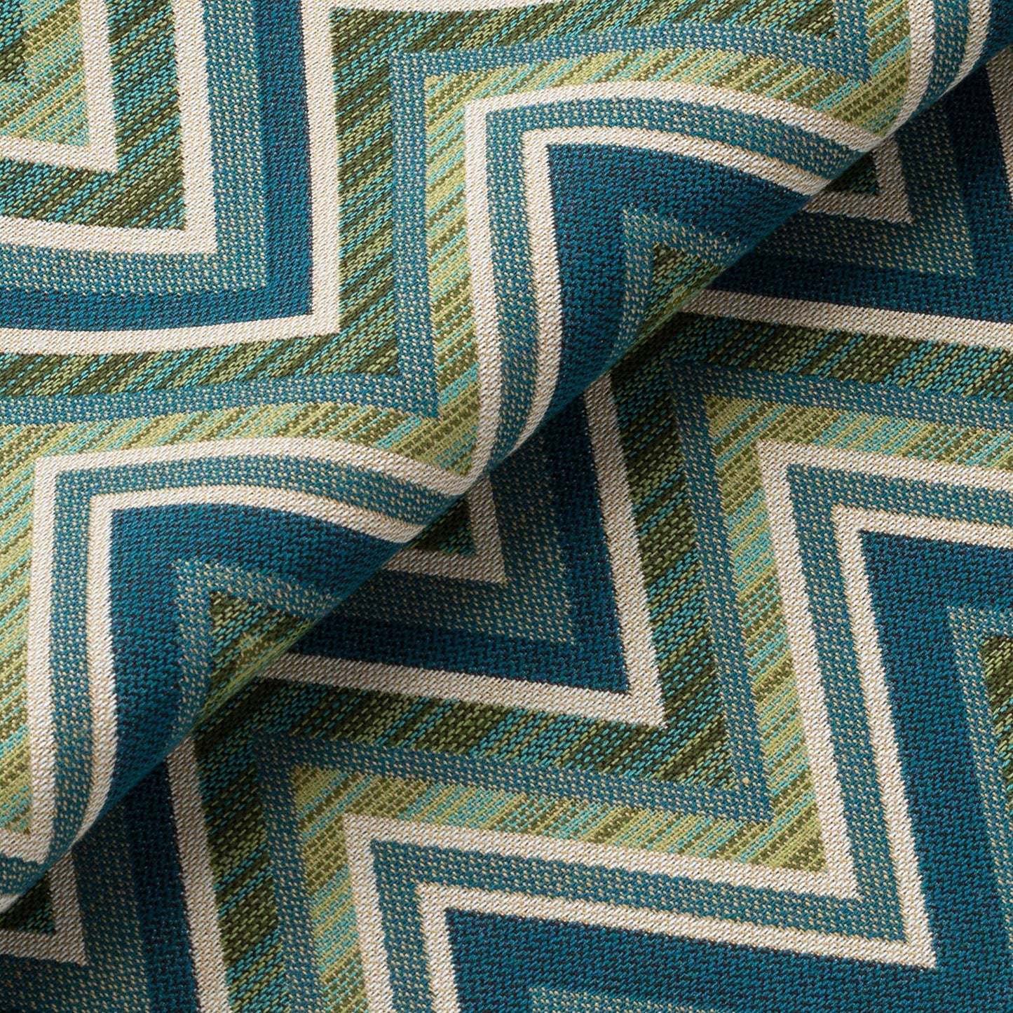 Close-up of a textured fabric with a geometric pattern in shades of blue and green.