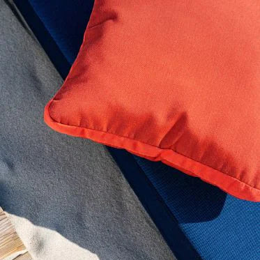 Close-up of a red pillow on a blue cushion with a wooden floor background