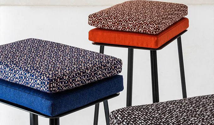 Three stools with patterned cushions in blue, red, and multicolor on a white background