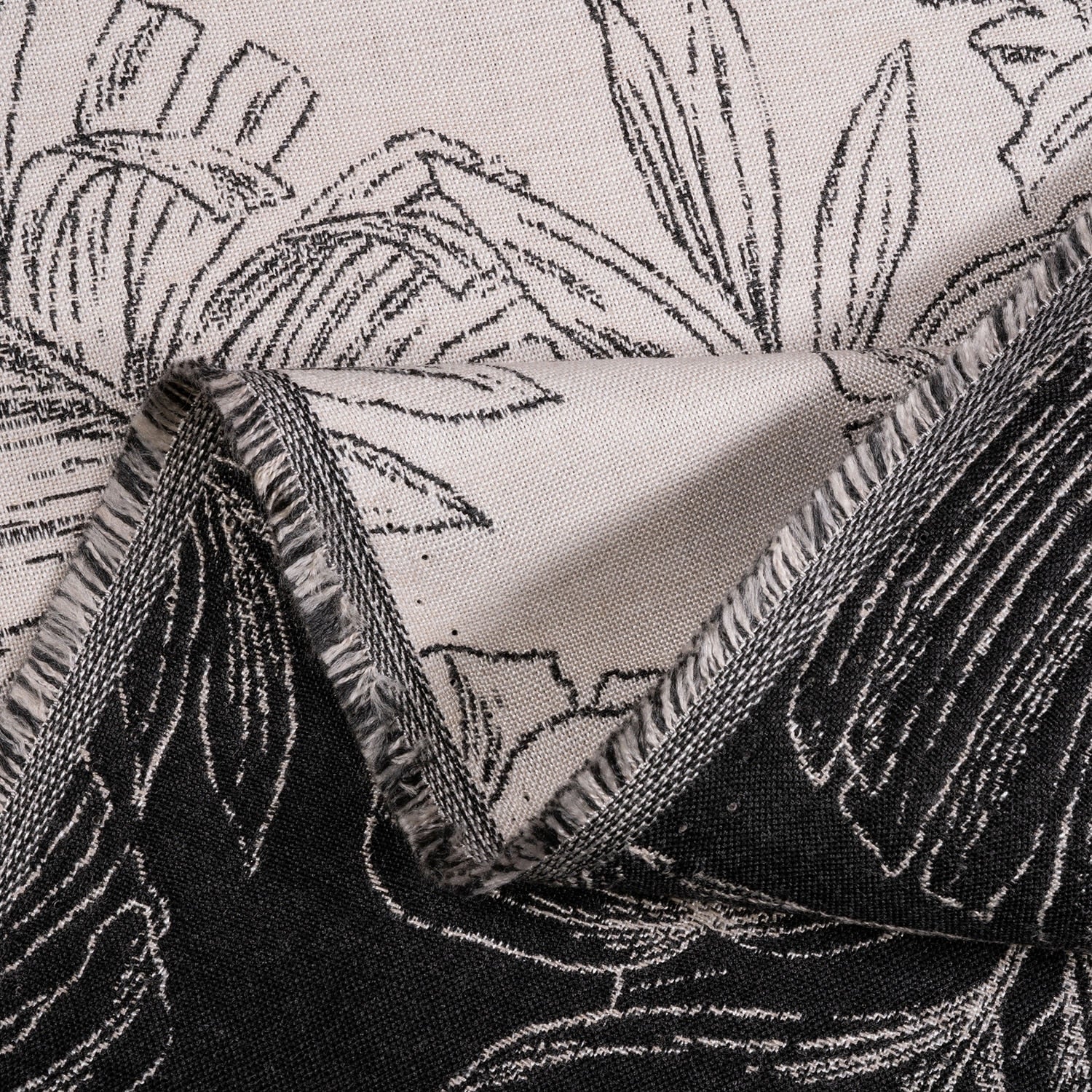 Close-up of fabric with black floral pattern on a neutral background