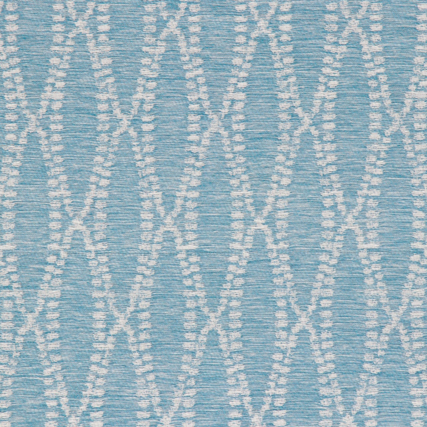 Close-up of a turquoise fabric with a white geometric pattern.