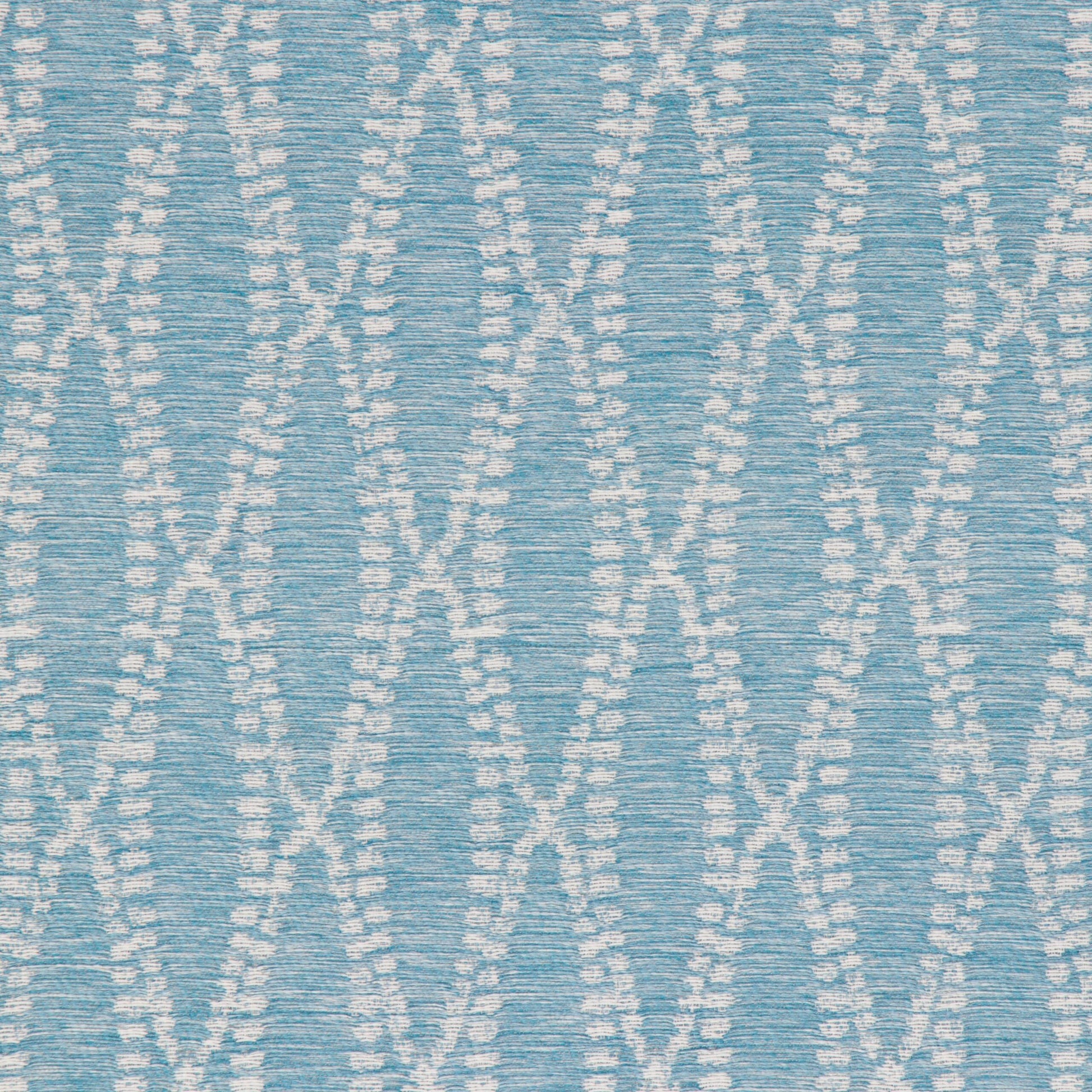 Close-up of a turquoise fabric with a white geometric pattern.