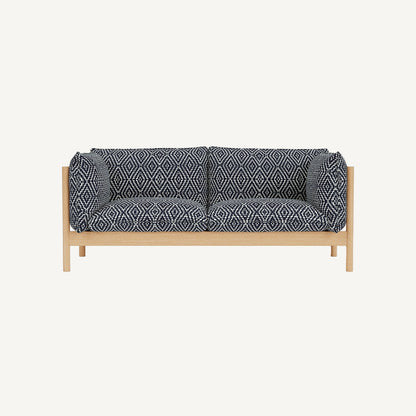 Sofa with dark blue patterned cushions on a white background