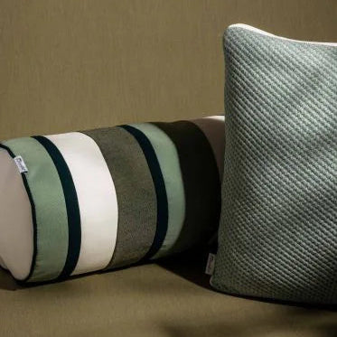Two pillows, one striped and one textured, on a brown surface.