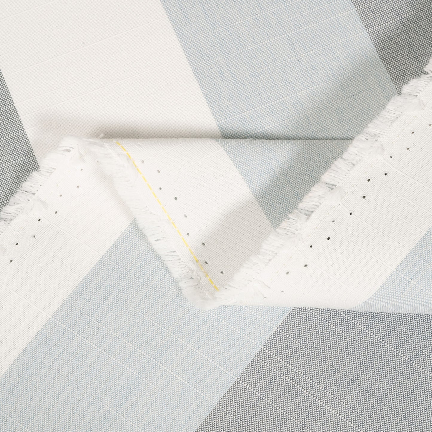 Close-up of a quilt with geometric pattern in gray and white.