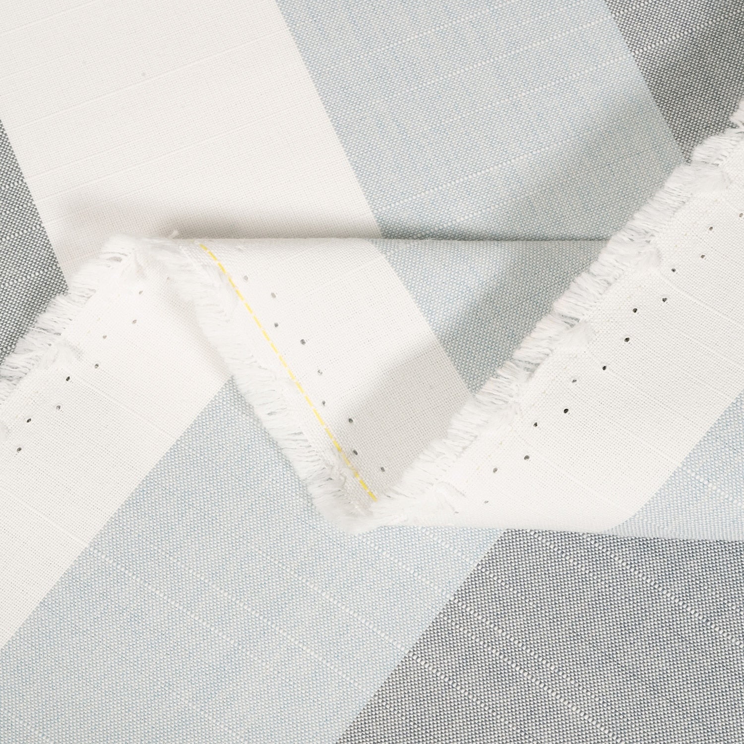 Close-up of a quilt with geometric pattern in gray and white.