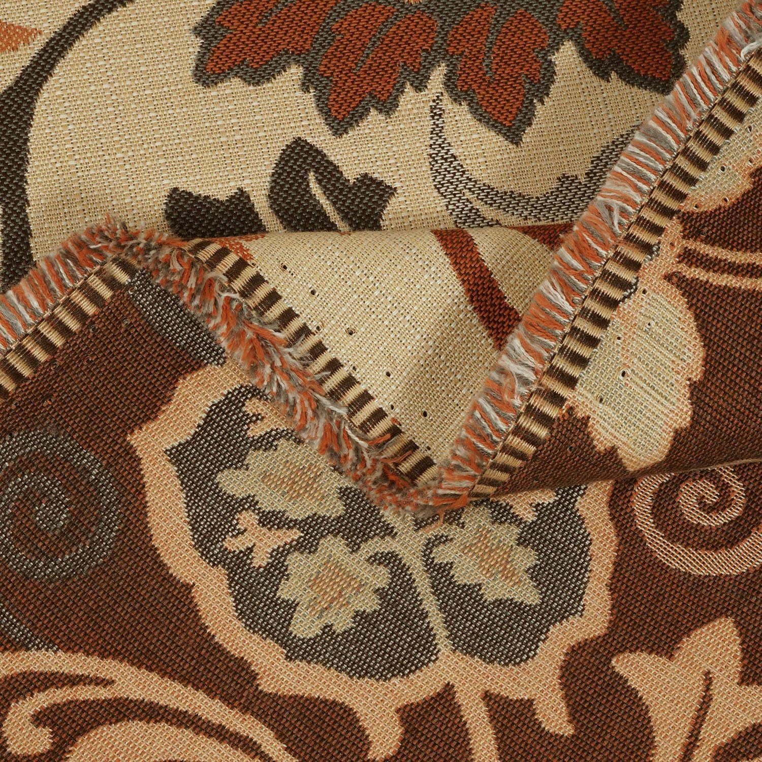 Close-up of a patterned fabric with intricate designs in brown, beige, and black.
