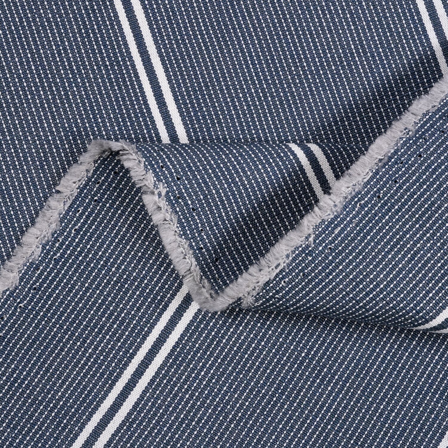 Close-up of blue fabric with white stripes and gray frayed edge