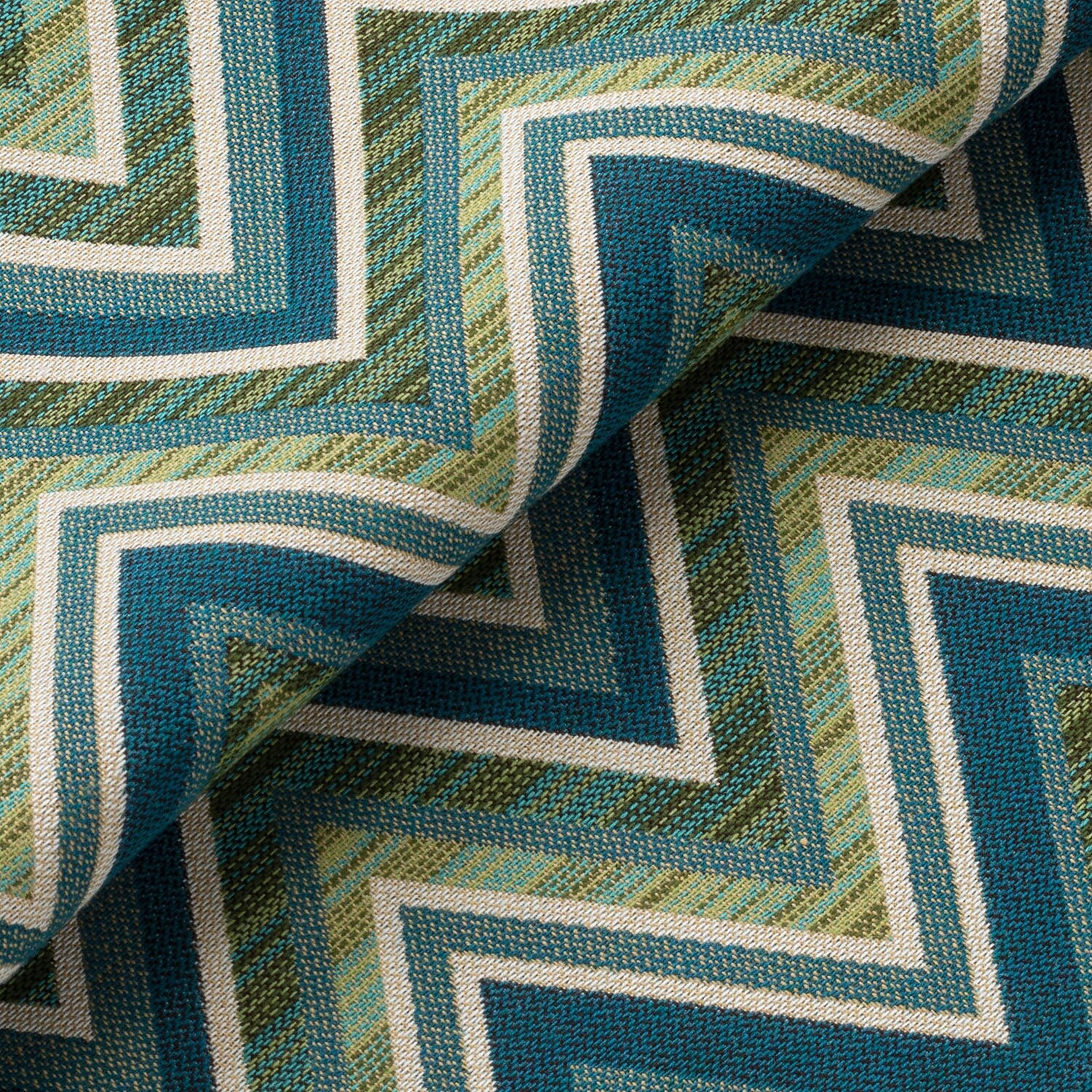 Close-up of a textured fabric with a geometric pattern in shades of blue and green.