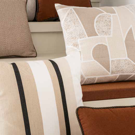 Close-up of decorative pillows with striped and patterned designs on a sofa.