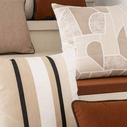 Close-up of decorative pillows with striped and patterned designs on a sofa.