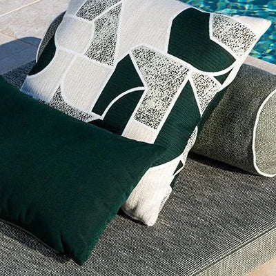 Decorative pillows on a lounge chair by a pool