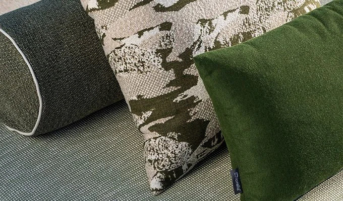 Three pillows on a textured surface with a camouflage pattern