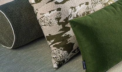 Three pillows on a textured surface with a camouflage pattern
