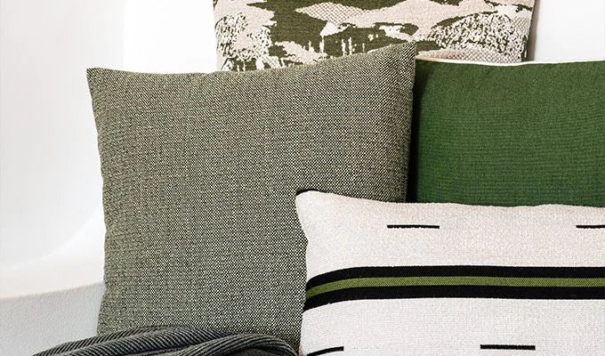 Collection of decorative pillows with different patterns and colors on a neutral background