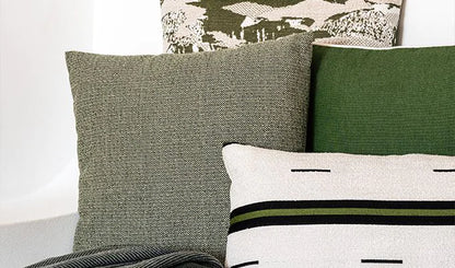 Collection of decorative pillows with different patterns and colors on a neutral background