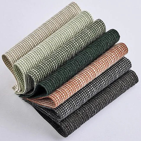 Stack of textured fabric samples in various colors on a light gray background