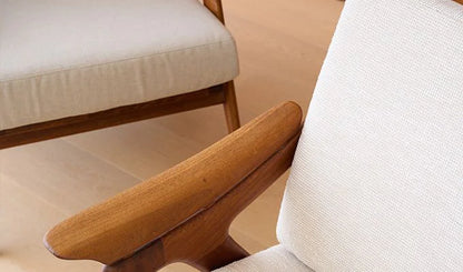 Close-up of a wooden armrest and beige cushion on a chair.