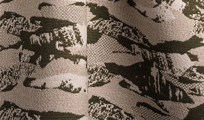 Close-up of a textured fabric with a camouflage pattern in shades of gray and black.