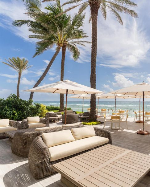 Outdoor seating area with palm trees and ocean view