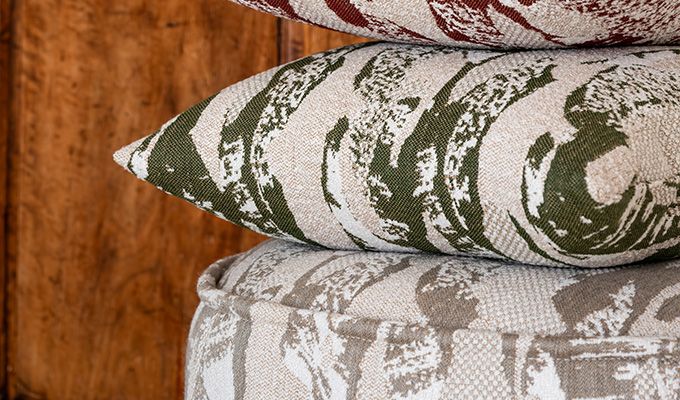 Stack of patterned pillows on a wooden surface